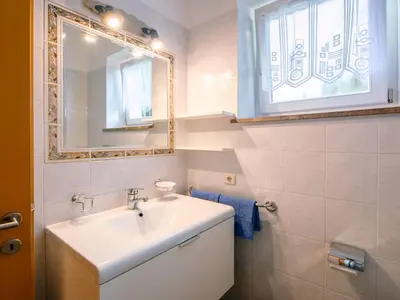 a white bathroom with a sink and a mirror at Apartment Wolfsthurn by Interhome in Andrian