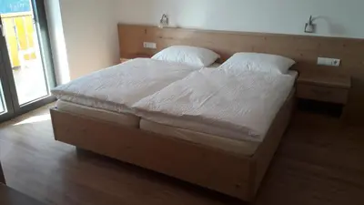a bed with white sheets and pillows in a bedroom at Residence Vellauerhof in Lagundo