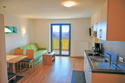 a kitchen and living room with a couch and a table at Residence Vellauerhof in Lagundo