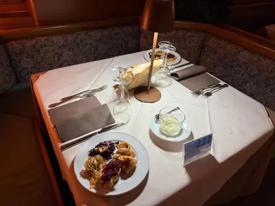 a white table with a plate of food on it at Hotel Marianna in Rocca Pietore