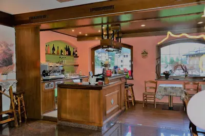 a kitchen with a bar and a dining room at Hotel Marianna in Rocca Pietore