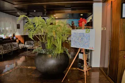 a large black vase with a plant in a room at Hotel Marianna in Rocca Pietore