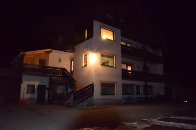 a building with a light on the side of it at night at Cesa Fossal in Colle Santa Lucia