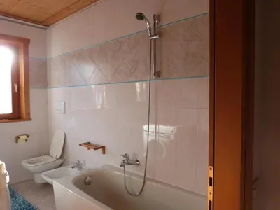 a bathroom with a shower and a tub and a toilet at Cesa Fossal in Colle Santa Lucia