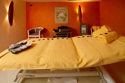 a large yellow bed in a room with orange walls at Family & Wellness Hotel Fontana in Vigo di Fassa