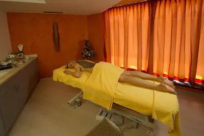 a woman laying on a bed in a hospital room at Family & Wellness Hotel Fontana in Vigo di Fassa