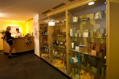 a woman is standing at a counter in a store at Family & Wellness Hotel Fontana in Vigo di Fassa