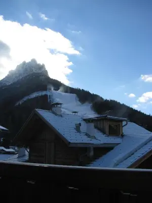 a roof of a building with snow on a mountain at Hotel Nès Crépes in Pozza di Fassa