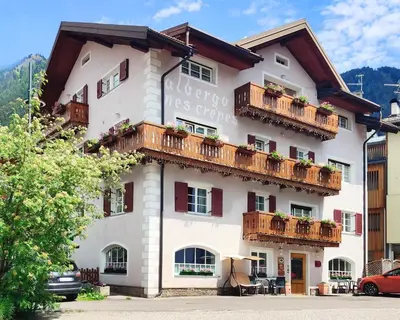 a large white building with balconies on it at Hotel Nès Crépes in Pozza di Fassa