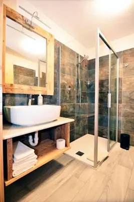 a bathroom with a sink and a shower at Wellness Hotel Dolomia in Soraga