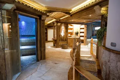 a largeoyer with a stone floor and wooden walls at Wellness Hotel Dolomia in Soraga