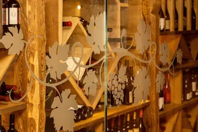 a display window of a wine cellar with wine bottles at Wellness Hotel Dolomia in Soraga