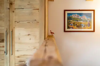a painting hanging on a wall next to a wall at Wellness Hotel Dolomia in Soraga