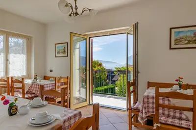 a dining room with two tables and a balcony at Agritur Cristina in Coredo