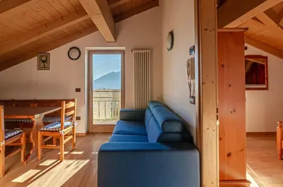 a living room with a blue couch and a table at Agritur Cristina in Coredo