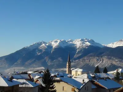 a town with snow covered mountains in the background at Agritur Cristina in Coredo