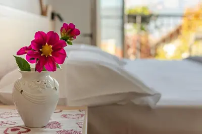 a white vase with flowers in it sitting on a table at Agritur Cristina in Coredo