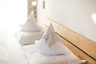 a row of white beds with hats on them at Untermairhof B&B Christine in Lagundo