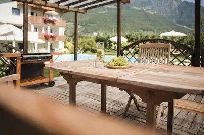 a wooden table with wine glasses and a bowl of grapes at Untermairhof B&B Christine in Lagundo