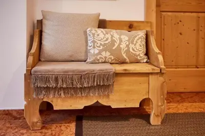 a wooden chair with a pillow in a room at Ciasa Verena in Corvara in Badia