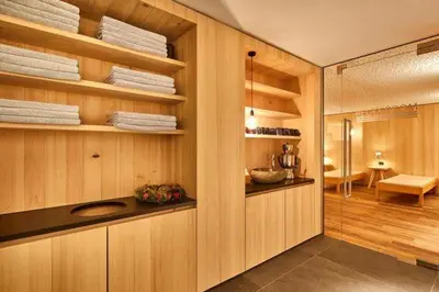 a bathroom with wooden walls and shelves with towels at Ciasa Verena in Corvara in Badia