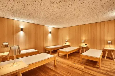 a room with wooden walls with benches and tables at Ciasa Verena in Corvara in Badia