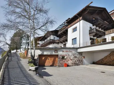 a yard with two large trees and grass at Apartment Tirol-2 by Interhome in Ortisei