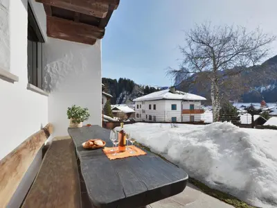 a wooden table on the balcony of a house at Apartment Tirol-2 by Interhome in Ortisei