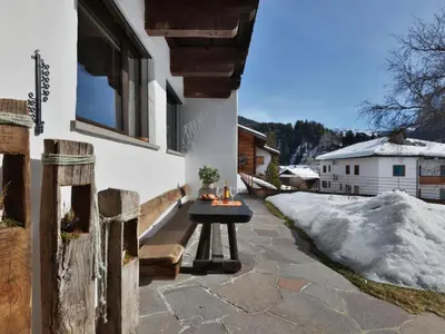 a table on the side of a house with snow at Apartment Tirol-2 by Interhome in Ortisei