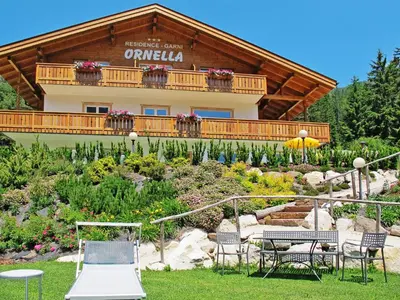 a building with a balcony with flowers on it at Apartment Ornella-1 by Interhome in Santa Cristina in Val Gardena