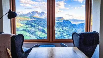 a table and chairs in a room with a large window at Tschott Hof in Villandro