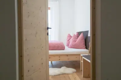 a room with a bench with pink pillows on it at Tschott Hof in Villandro