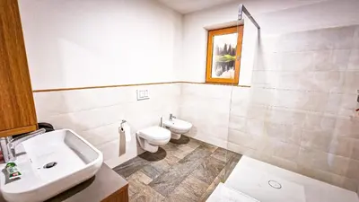 a bathroom with a sink and a toilet and a window at Tschott Hof in Villandro