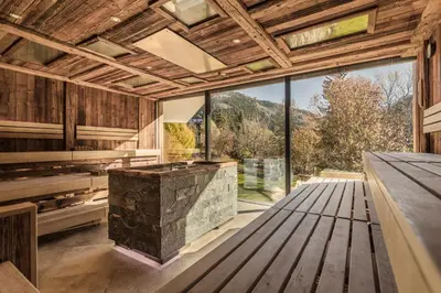 an open kitchen with a large window and a stone island at Engel Gourmet&Spa in Nova Levante