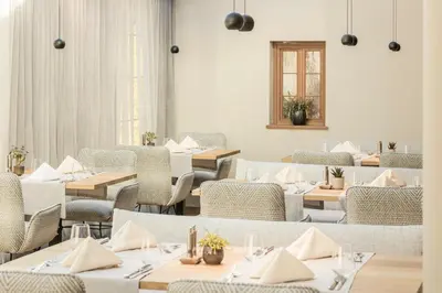 a restaurant with tables and chairs and a window at Engel Gourmet&Spa in Nova Levante