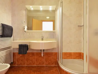 a hotel room with a bed and a bathroom at Apartment Garden 102 by Interhome in Villandro