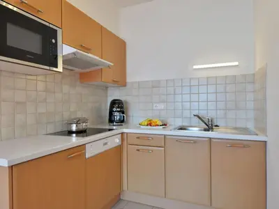 a living room with a couch and a kitchen at Apartment Garden 102 by Interhome in Villandro