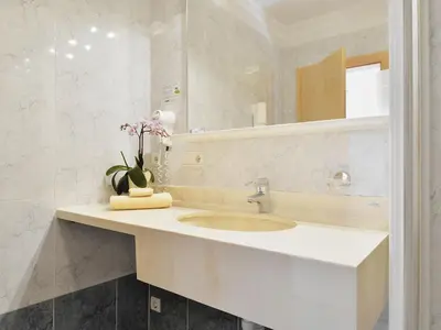 a large white building with a swimming pool next to a hill at Apartment Comfort 202 by Interhome in Villandro