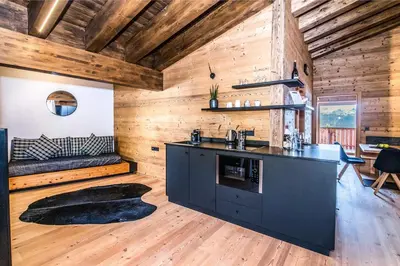 a kitchen with a counter and a couch in a room at Chalet Stern in Vipiteno