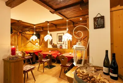 a dining room with tables and chairs and wine bottles at Hotel Tirol- Natural Idyll in Montesover