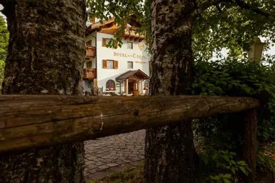 a wooden fence in front of a building between two trees at Hotel Tirol- Natural Idyll in Montesover