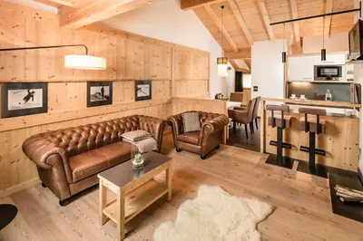 a living room with leather couches and a table at Lagació Hotel Mountain Residence in San Cassiano