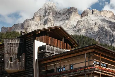 a building with a mountain in the background at Lagació Hotel Mountain Residence in San Cassiano