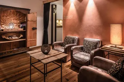 a living room with leather chairs and a table at Lagació Hotel Mountain Residence in San Cassiano
