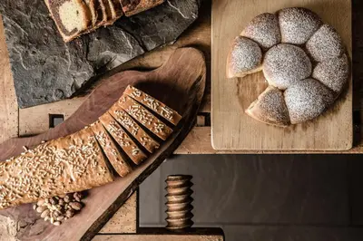 a wooden cutting board with bread and a pair of shoes at Lagació Hotel Mountain Residence in San Cassiano