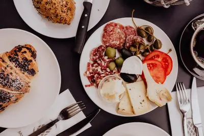 a table with three plates of food on it at Martinerhof's Brauhotel in San Martino