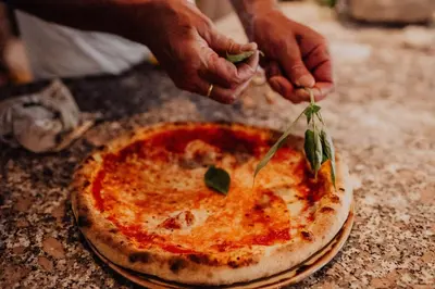 a person cutting into a pizza on a table at Martinerhof's Brauhotel in San Martino