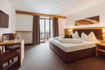 a hotel room with a bed and a desk at Martinerhof's Brauhotel in San Martino