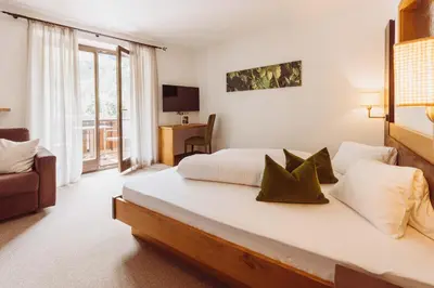 a hotel room with a bed and a couch at Martinerhof's Brauhotel in San Martino