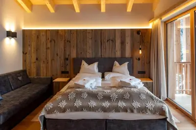 a bedroom with a large bed and a couch at Hotel Rezia in La Villa